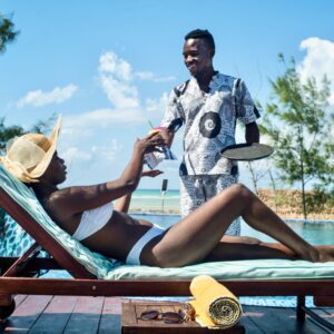 Coral Lodge Pool Lady on lounger with waiter serving
